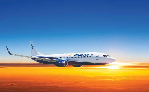 Blueair Airline flying over a beautiful sunset.